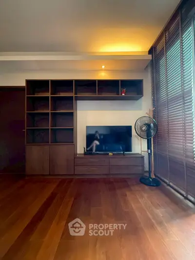 Spacious living room with wooden flooring and modern entertainment unit