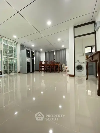 Spacious open-plan living and dining area with modern appliances and sleek flooring.