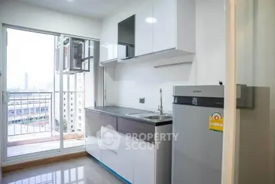 Modern kitchen with sleek cabinets and balcony view in urban apartment