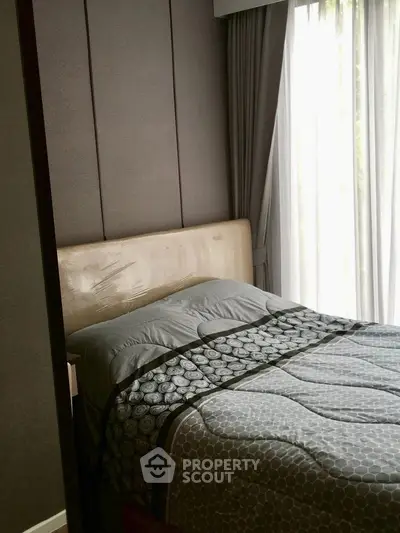 Cozy bedroom with elegant decor and large window for natural light