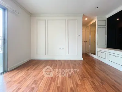 Spacious empty room with wooden flooring and elegant wall panels