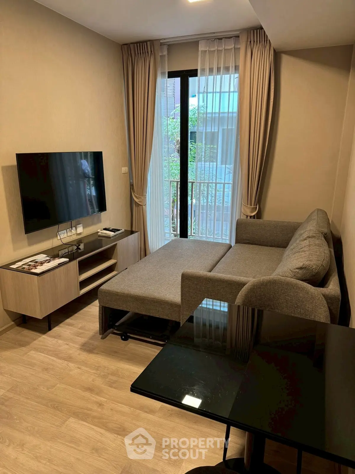 Modern living room with sleek furniture and large window, perfect for urban living.