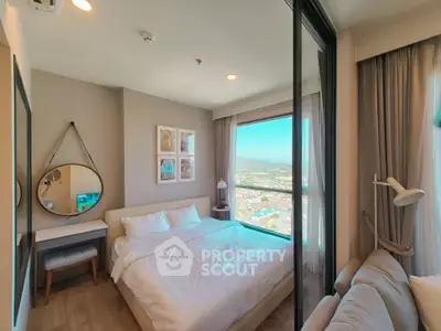 Cozy bedroom with large window offering stunning city view, modern decor, and ample natural light.
