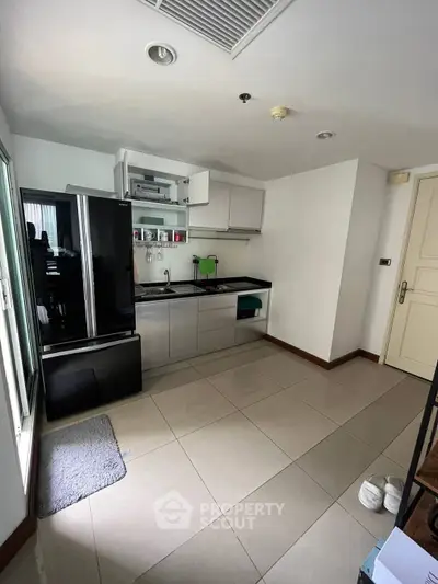 Modern compact kitchen with sleek appliances and open layout in a stylish apartment.
