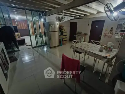 Spacious open-plan living area with dining table and modern kitchen appliances.