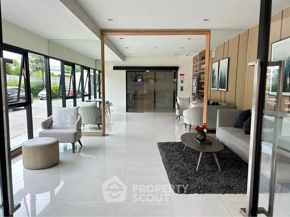Modern lobby with sleek furniture and large windows in a contemporary building.