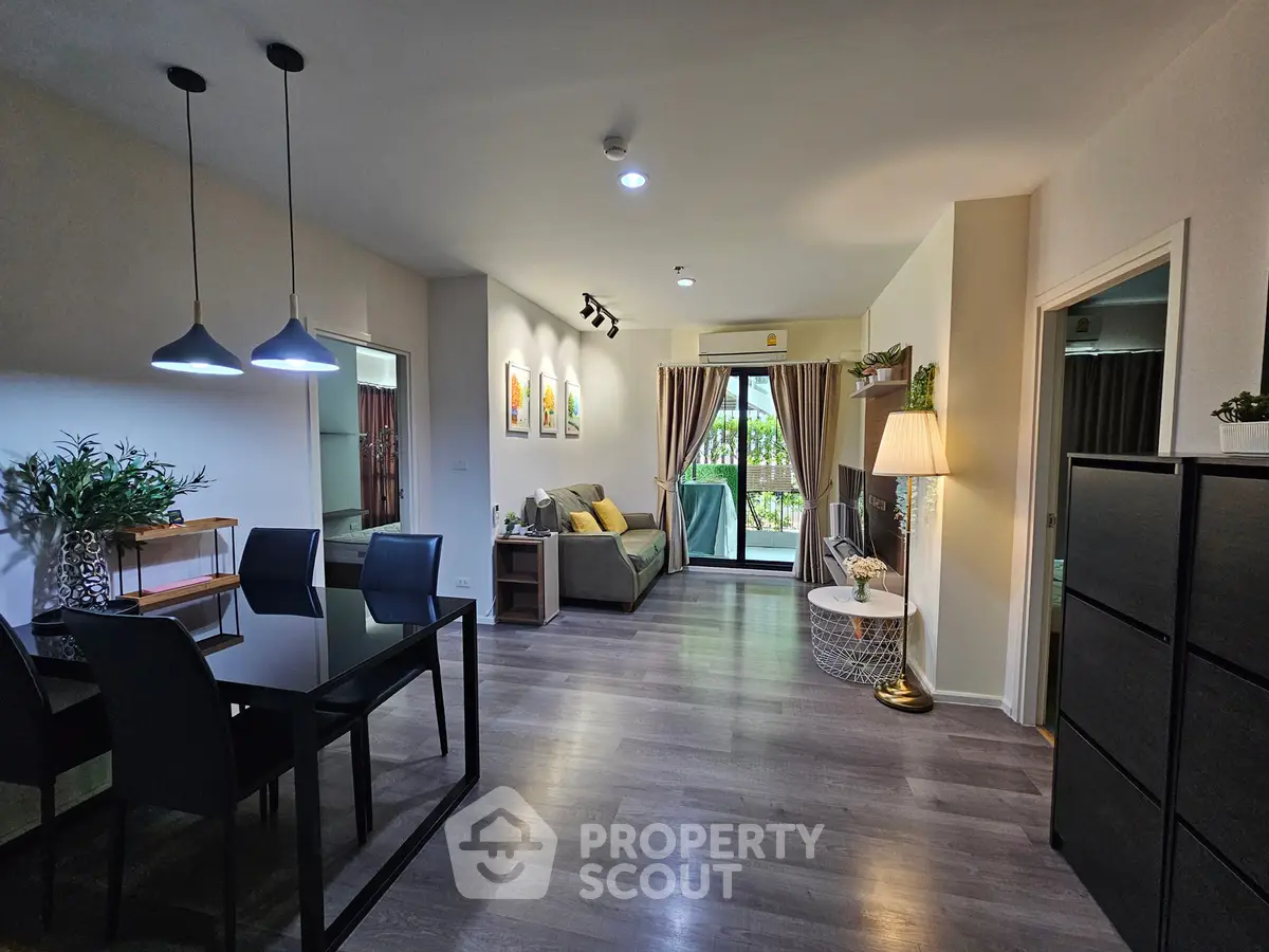 Spacious modern living room with dining area and balcony view, featuring stylish decor and ample natural light.