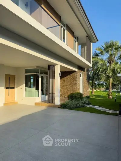 Modern luxury home exterior with spacious driveway and lush landscaping