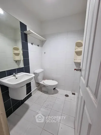 Compact bathroom with white tiles and modern fixtures