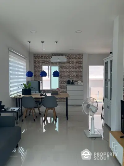 Modern dining area with stylish lighting and brick accent wall