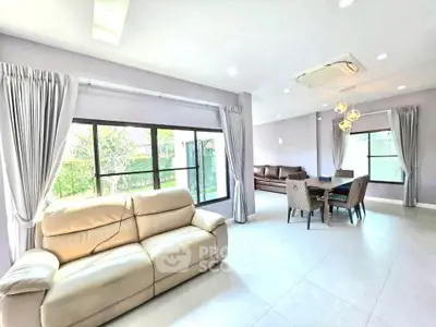 Spacious modern living room with large windows and elegant dining area