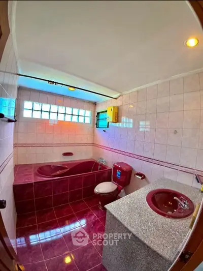Unique bathroom with vibrant red fixtures and modern design