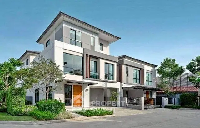 Modern two-story house with sleek design and lush landscaping in a serene neighborhood.