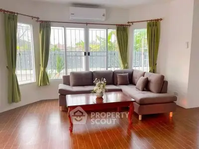 Spacious living room with large windows and elegant corner sofa