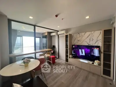 Modern living room with stylish decor and balcony view in a high-rise apartment.