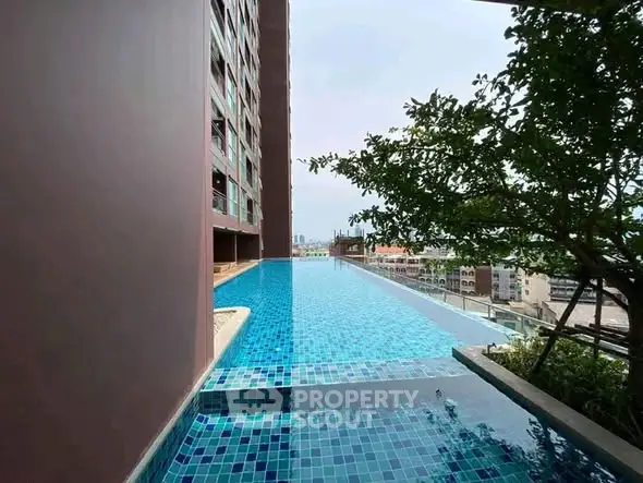 Luxurious high-rise building with stunning infinity pool and city view, perfect for urban living.