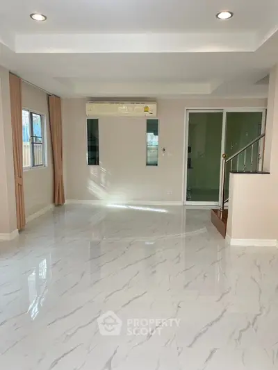 Spacious modern living room with marble flooring and large windows