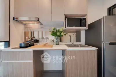 Modern kitchen with sleek cabinetry, stainless steel appliances, and elegant decor in a stylish apartment.
