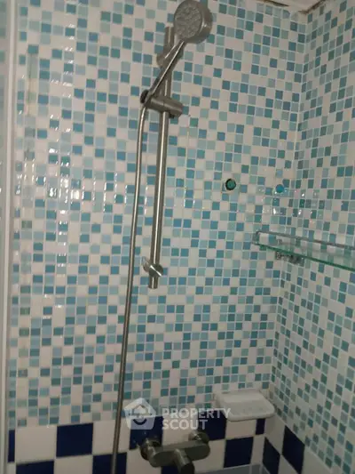 Modern bathroom with stylish blue mosaic tiles and sleek shower fixtures.