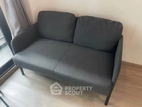 Modern gray sofa in a cozy living room with wooden flooring and natural light.