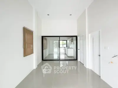 Spacious modern interior with sleek tile flooring and open kitchen layout, perfect for contemporary living.