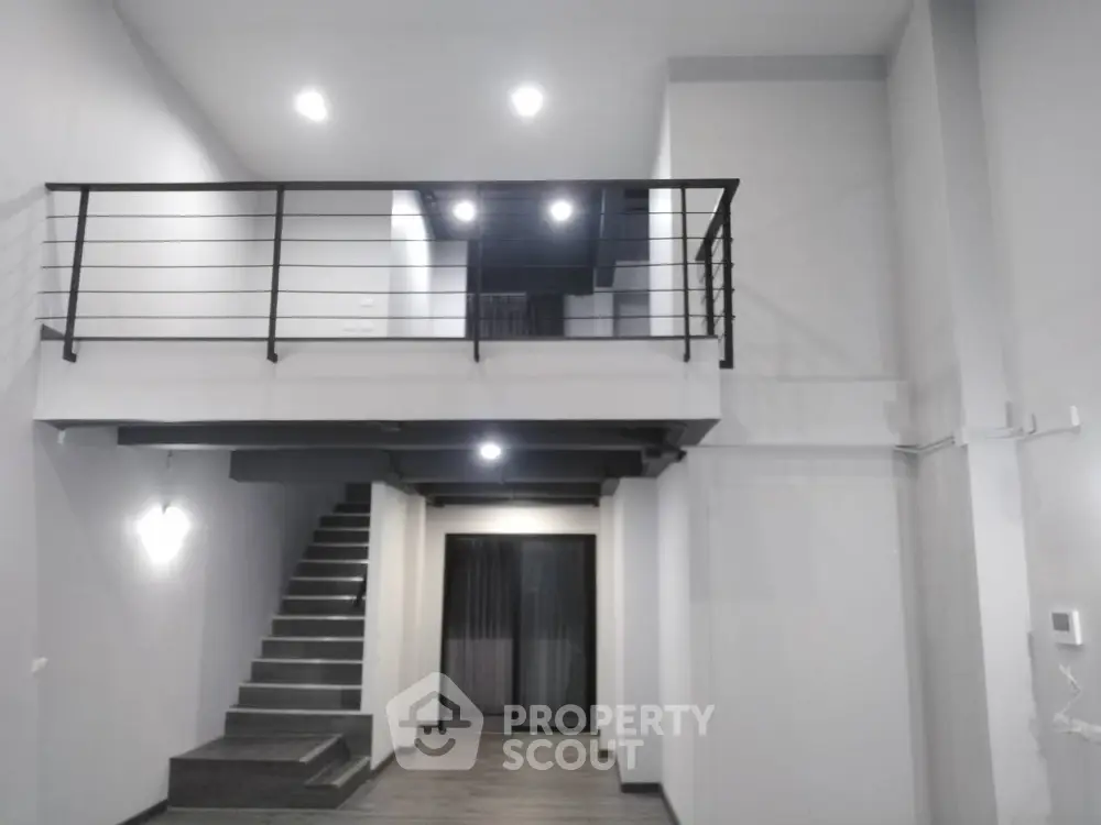 Modern loft-style interior with high ceilings and mezzanine level