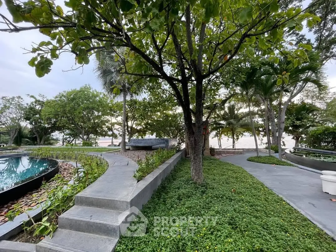 Lush garden with pathways and serene water feature in a tranquil real estate setting.