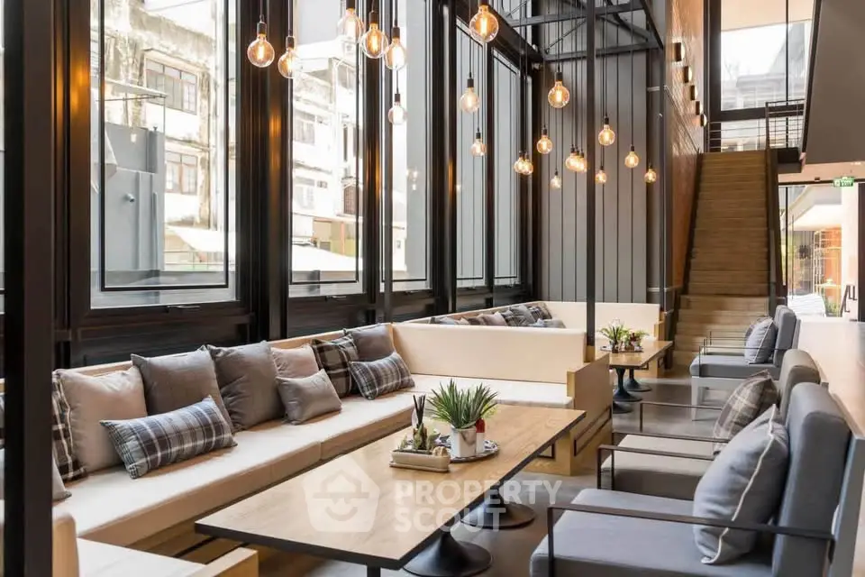 Modern living area with stylish seating and large windows in a contemporary building.