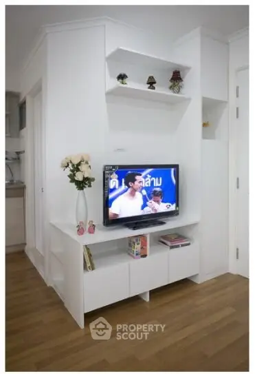 Modern living room with sleek white entertainment unit and wooden flooring