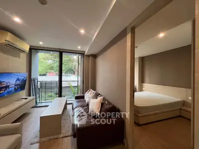 Modern living room with cozy seating and adjacent bedroom, featuring large windows and stylish decor.