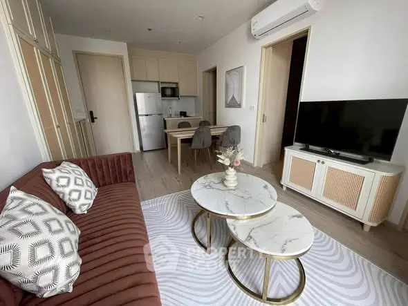 Modern living room with stylish furniture and open kitchen layout in a cozy apartment.