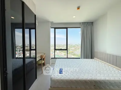 Modern bedroom with large window offering stunning city view, featuring sleek furniture and ample natural light.