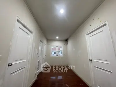 Spacious hallway with wooden flooring and white doors, ideal for modern home design.