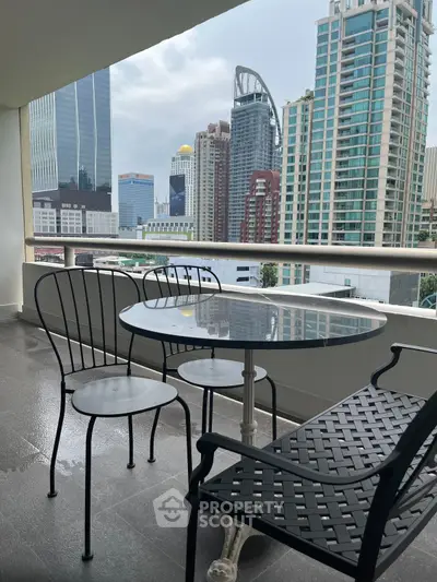 Stunning city view from a modern balcony with stylish outdoor seating.