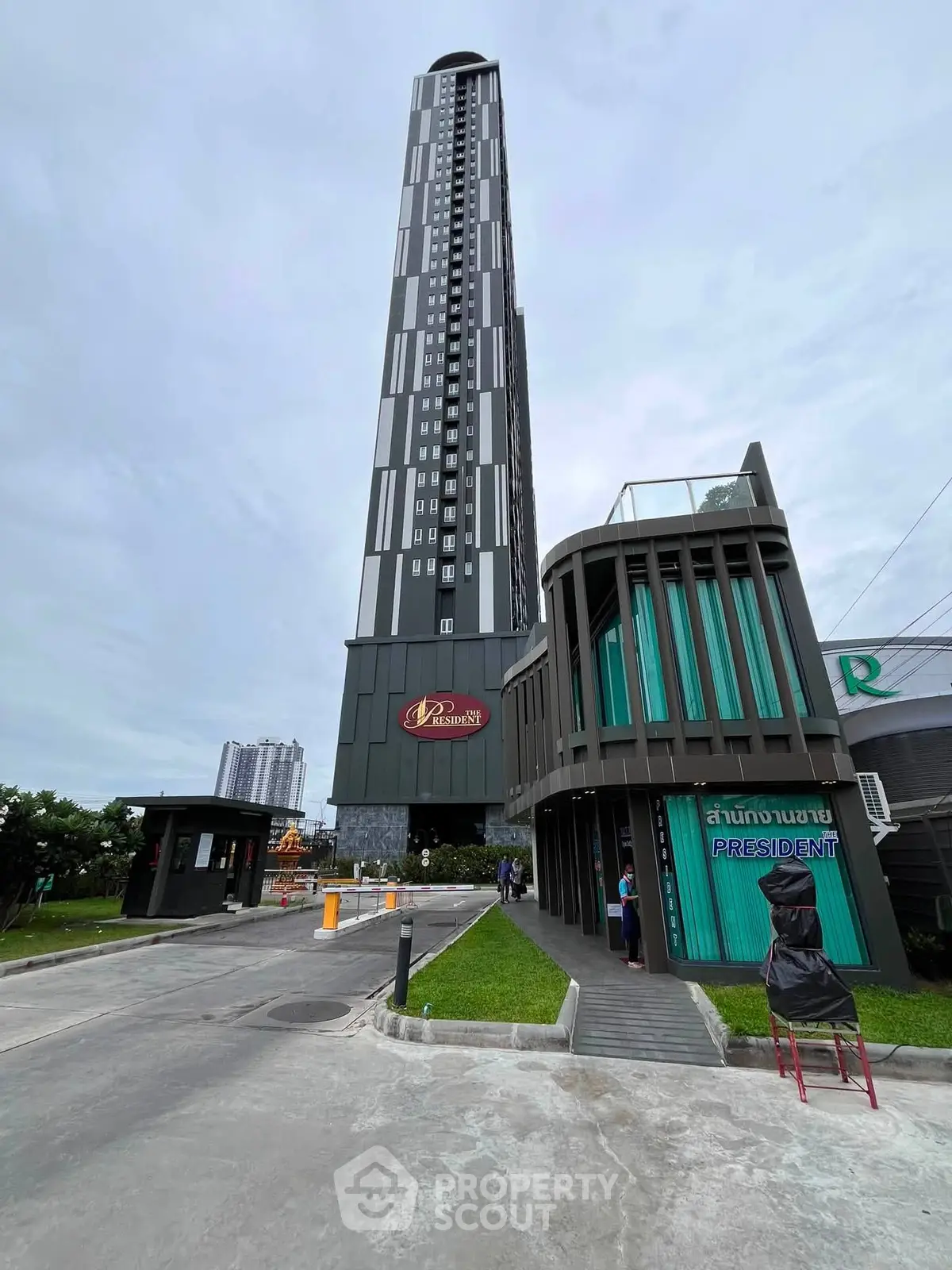 Modern high-rise building with sleek design and lush surroundings, ideal for urban living.
