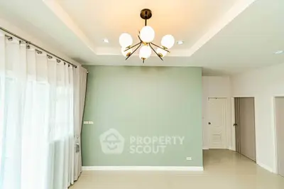 Spacious living room with modern chandelier and elegant curtains in a bright, minimalist design.