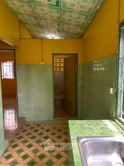 Charming vintage kitchen with colorful tiles and open layout, perfect for creative renovation.
