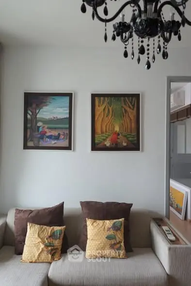 Cozy living room with elegant chandelier and artistic wall paintings