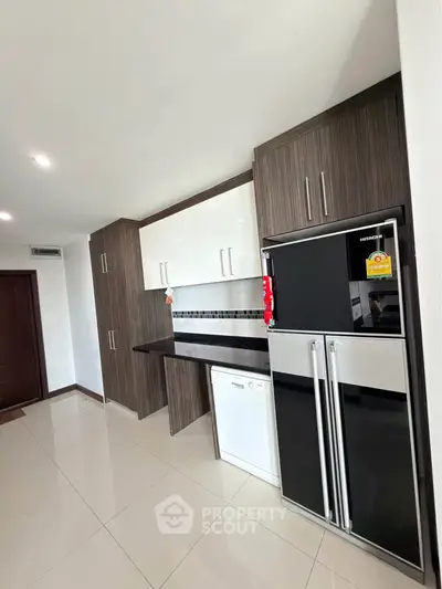 Modern kitchen with sleek cabinetry and stainless steel appliances in a stylish apartment.