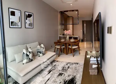 Modern living room with stylish decor and open dining area in a contemporary apartment.
