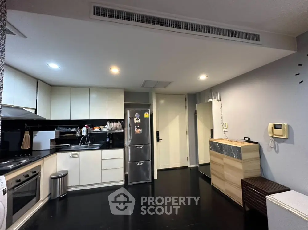Modern kitchen with sleek cabinets and stainless steel appliances in a stylish apartment.