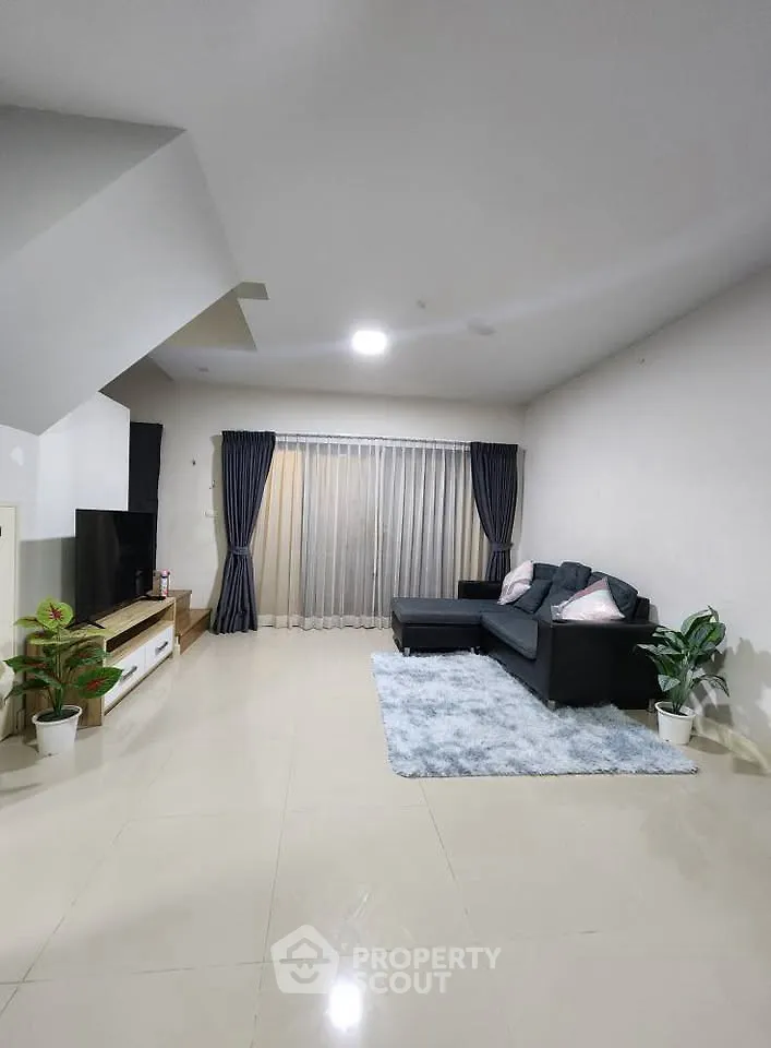 Spacious modern living room with sleek furniture and large windows for natural light.