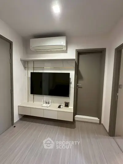 Modern living room with wall-mounted TV and air conditioning unit.