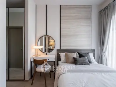 Modern bedroom with stylish decor and natural light, featuring a cozy bed and elegant vanity area.