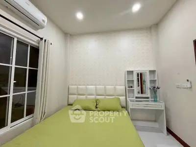 Cozy bedroom with green bedding and elegant vanity in modern apartment.