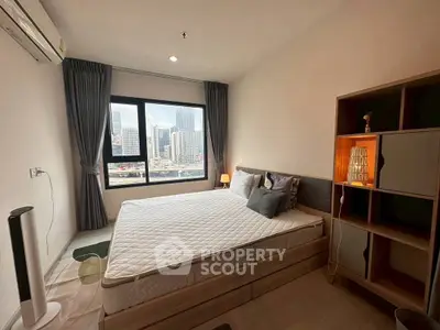 Modern bedroom with city view, featuring stylish furniture and ample natural light.
