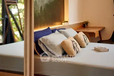 Cozy bedroom with modern decor and natural light, perfect for relaxation.