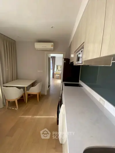 Modern kitchen with sleek design and dining area in a bright apartment.