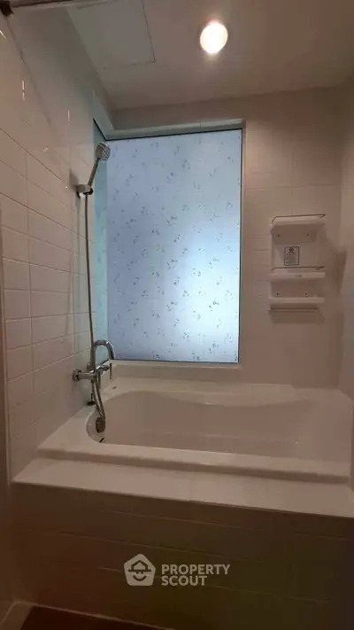 Modern bathroom with bathtub and shower, featuring elegant tile design and soft lighting.