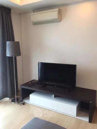 Modern living room with sleek TV stand and air conditioning unit, perfect for cozy entertainment.